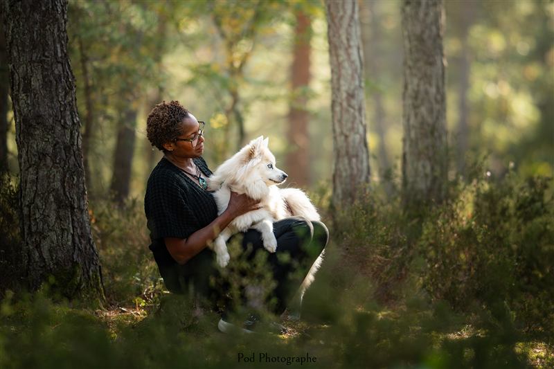 Une personne assise en forêt avec son chien